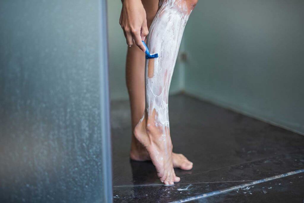 close up von damenbeim rasieren unter der dusche