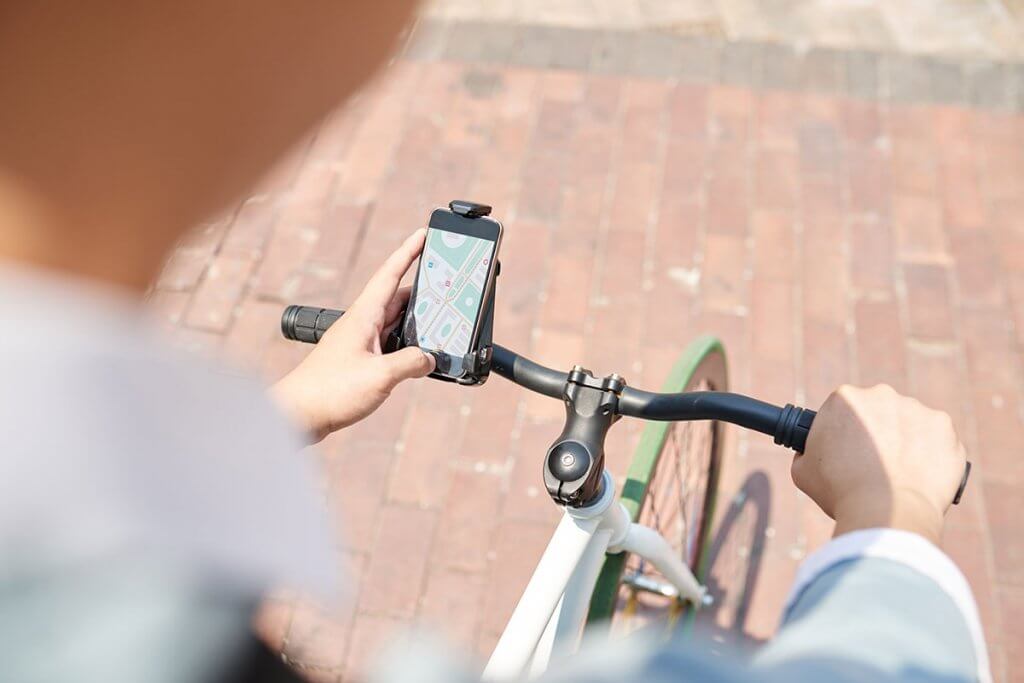 person bedient smartphone am fahrradlenker
