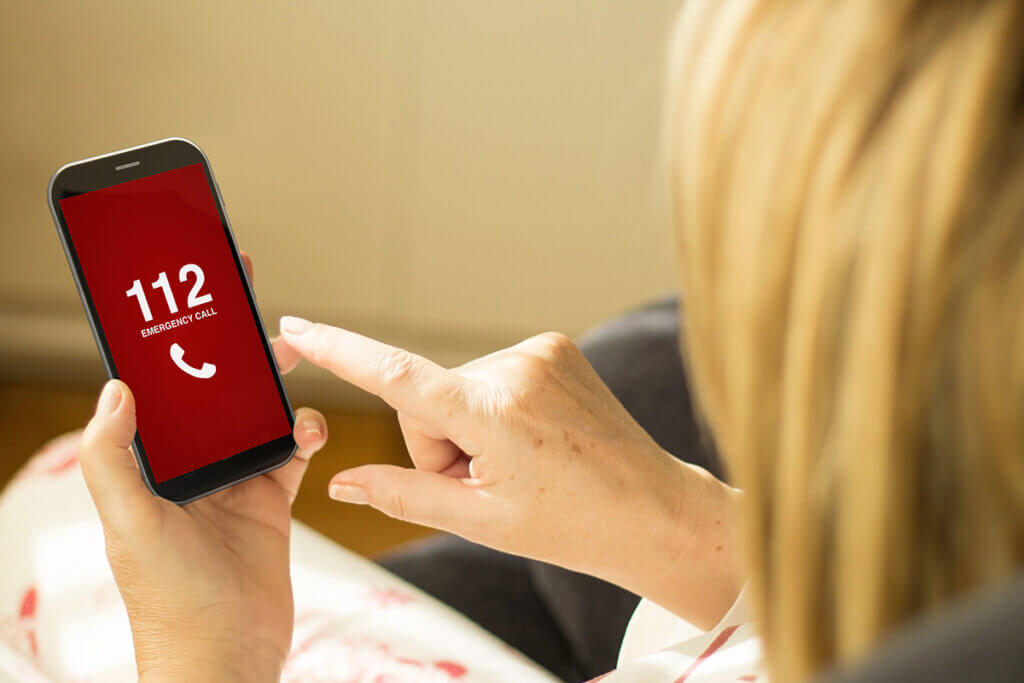 Frau wÀhlt Notruf auf Handy
