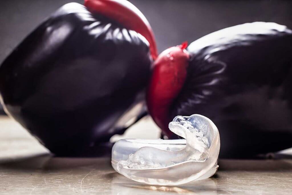 standboxsack-boxhandschuhe_und_zahnschutz_auf_gym_boden