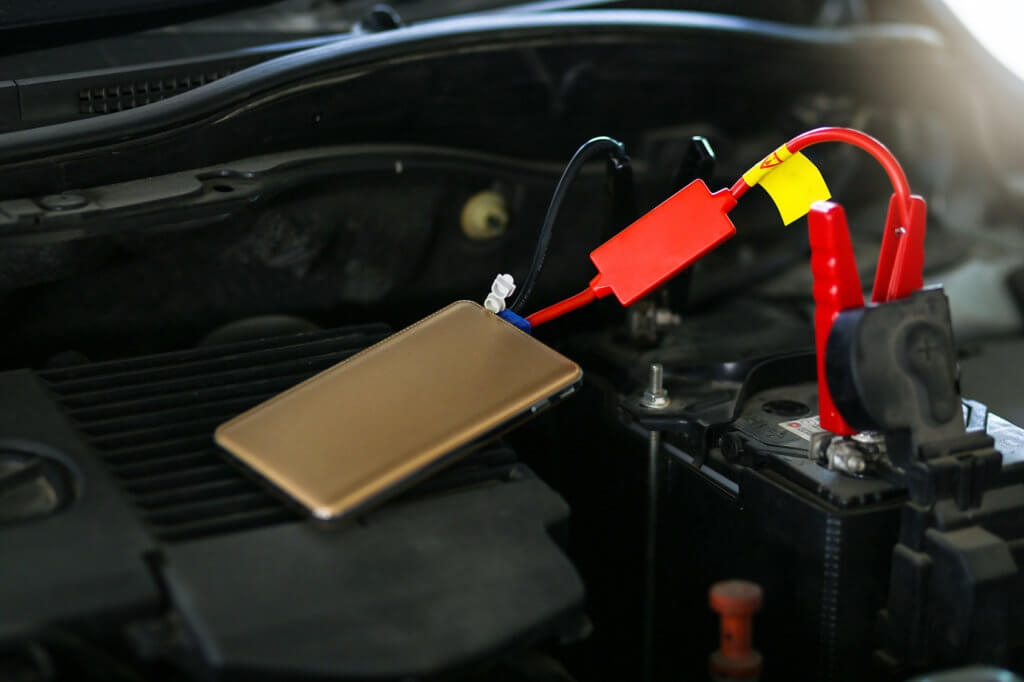 Kleine Starthilfegeraet haengt an Autobatterie